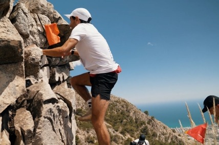 Corredor escala por una gran roca.